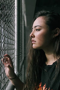 woman wearing black shirt holding fence thumbnail