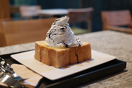 whipped cream and chocolate syrup on top of cake thumbnail