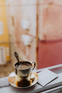 Drink coffee in a golden cup at the window thumbnail