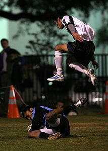 two men playing soccer on field thumbnail