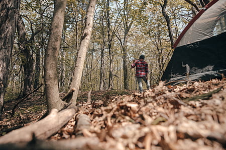 Camper Standing Beside Tent With Axe Photo thumbnail