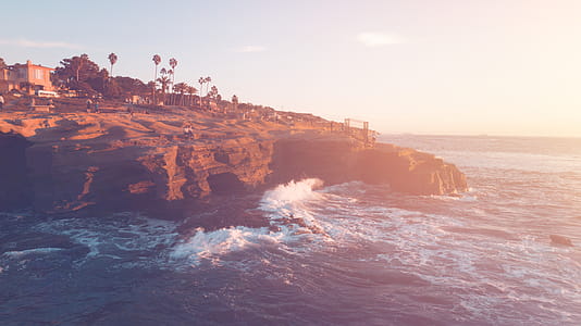 Brown Cliff Beside Ocean Under Blue Sky thumbnail