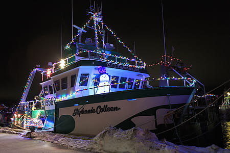 PORT DE GRAVE, NEWFOUNDLAND AND LABRADOR, CANADA - DECEMBER 22, 2017. Fishing vessels at night celebrating the Christmas season with lights, taken on December 22, 2017 in Port De Grave. thumbnail
