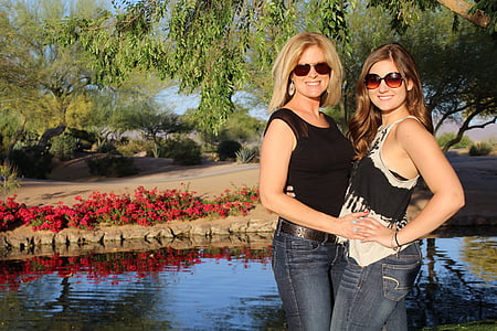 two women standing beside body of water thumbnail
