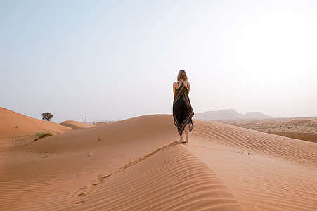 woman stands on brown sand thumbnail