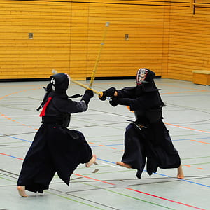 two people having a wooden sword sparring indoors thumbnail