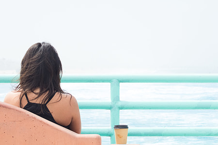 woman sitting on beige chair facing terrace thumbnail