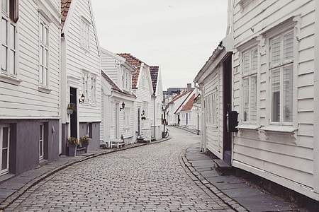 landscape photography of road between houses at daytime thumbnail