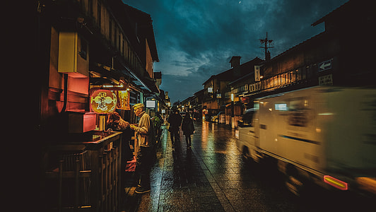 man standing near food stall at night time thumbnail