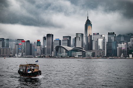 brown boat near high rise buildings thumbnail