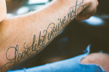 person showing black arm tattoo thumbnail