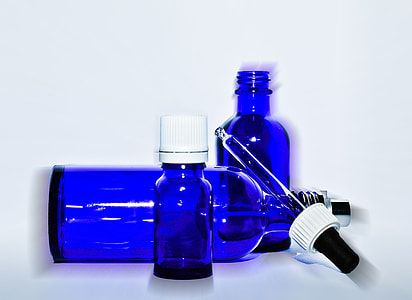 three blue glass bottles with dropper closeup photo thumbnail
