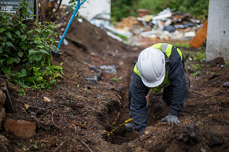 man wearing hardhat doing work on soil during daytime thumbnail
