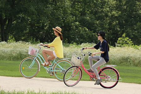 two women riding bicycles during daytime thumbnail