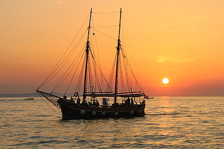 black junk boat on body of water during sunset thumbnail