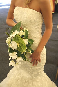 woman wearing white lace wedding gown and holding bouquet thumbnail