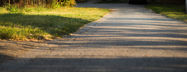 grey concrete road between green grass field thumbnail