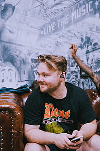 man in black shirt sitting on leather cushion armchair thumbnail