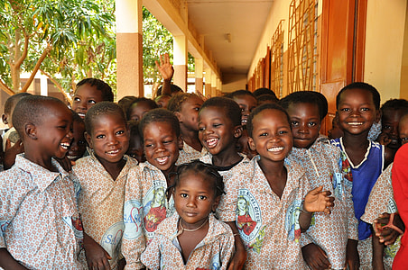photo of children wearing red-and-white uniform in brown painted concrete building thumbnail