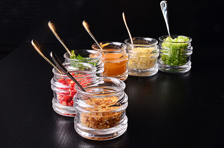 six assorted spices on jars on black surface thumbnail