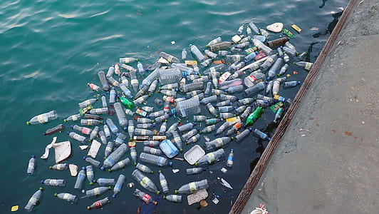 assorted plastic bottles on body of water during daytime thumbnail