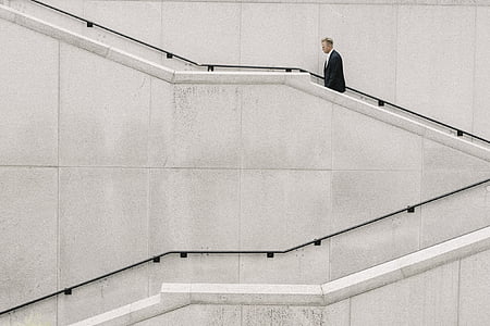 man walking on the stairs beside the wall thumbnail