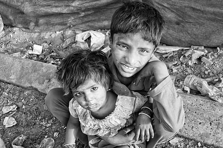 boy holding girl while sitting on ground thumbnail
