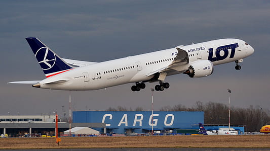 white airplane under cloudy sky thumbnail