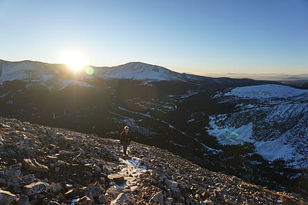 Person Walking on Mountain Covered in Stones thumbnail