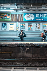 woman sitting of train bench while using phone thumbnail