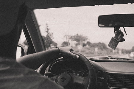 grayscale photography of man driving car thumbnail