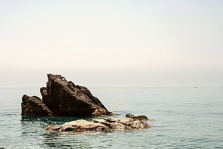 photo of black and grey rocks under cloudy sky thumbnail