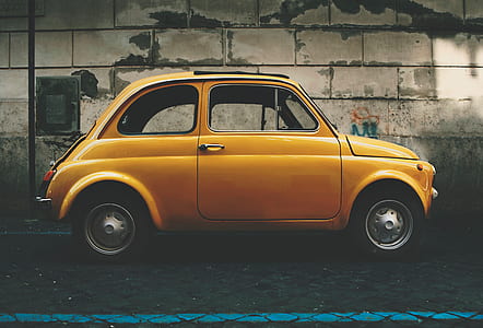 yellow 3-door hatchback parked near gray wall thumbnail