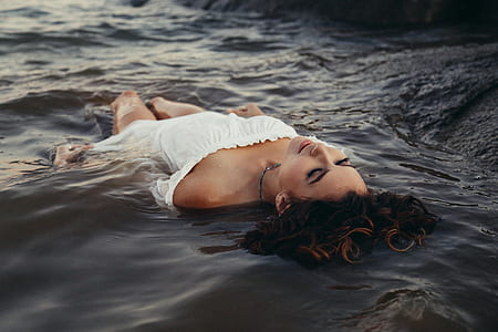 woman with closed eyes floating on water thumbnail