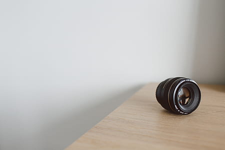 black DSLR camera lens on brown wooden surface thumbnail