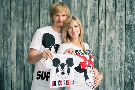 man and woman holding Mickey Mouse shirt thumbnail
