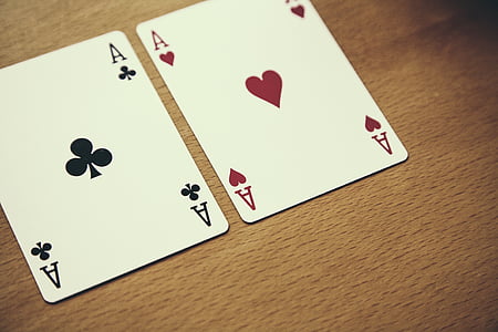 selective focus photography of two aces of hearts and clove playing cards on brown surface thumbnail