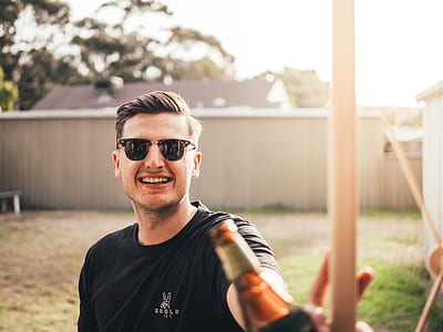 man holding brown glass bottle thumbnail