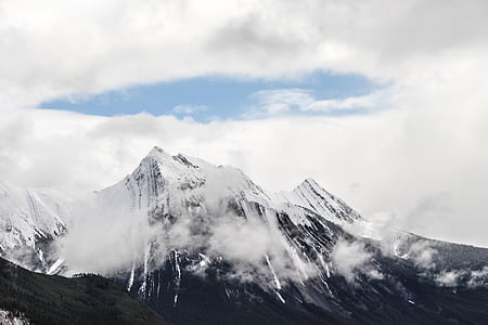 mountain covered with snow near clouds thumbnail