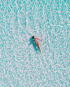 woman floating on body of water thumbnail