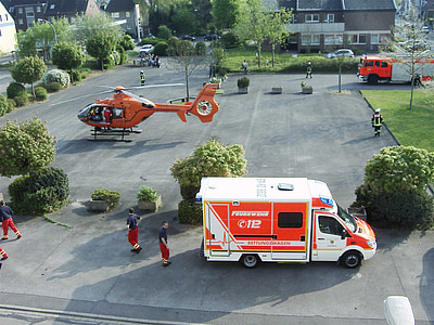 white and orange vehicle near people and helicopter thumbnail