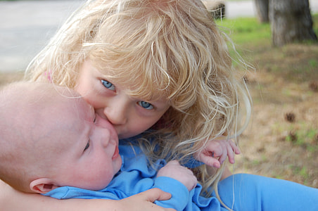 blonde haired girl kissing baby thumbnail