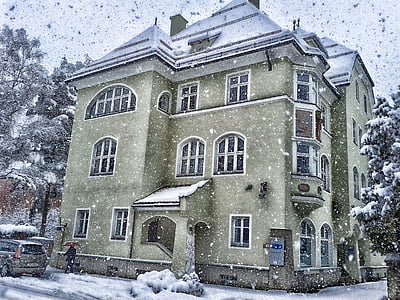 person holding umbrella walking near green concrete house during snow thumbnail