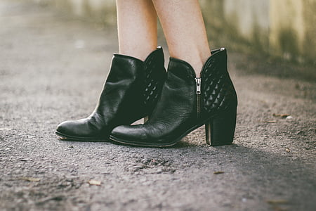 woman wearing pair of black leather heeled booties thumbnail