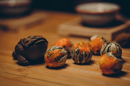 Brown Frog Figurine Beside Orange and Gray Fruits thumbnail
