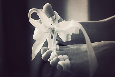 grayscale photo of human feet with white ribbon thumbnail