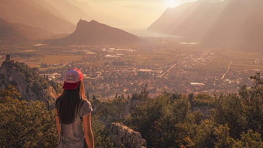 woman wearing white and red cap looking in front of city thumbnail