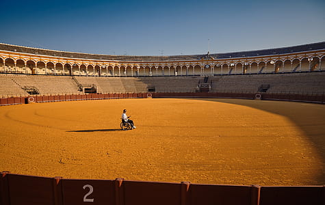 person sitting on wheelchair in the middle of stadium thumbnail