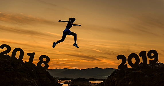 silhouette of woman jumping between rock formation during golden hour thumbnail