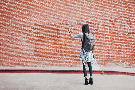 girl wearing gray shirt standing near brown brick wall at daytime thumbnail